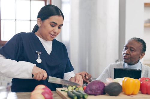 Caregiver, cooking and senior woman in home with healthy food, vegetables and nutrition in healthca.
